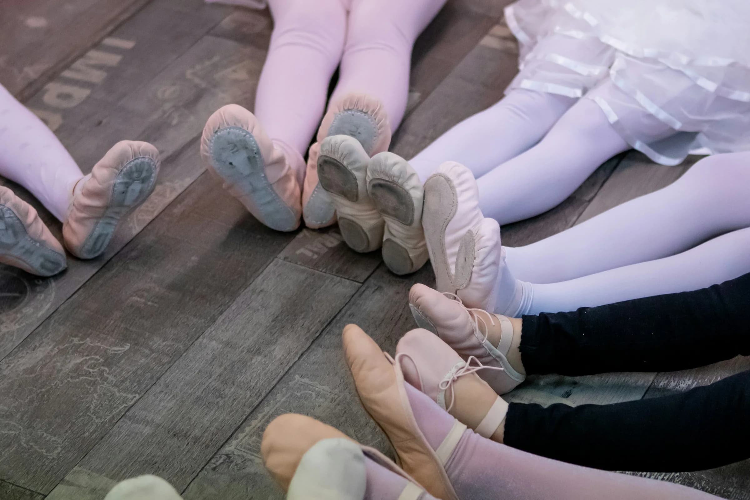 Allieve sedute in cerchio con scarpette da danza